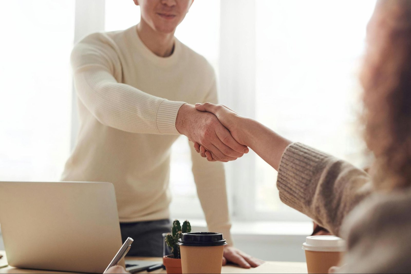A man shaking hands with a job interviewer at an office interview