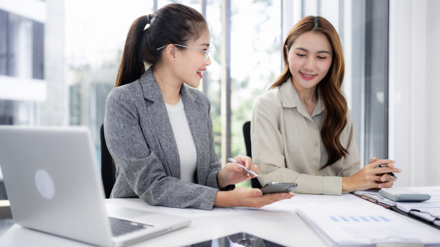 Two HR professionals in a Singapore office reviewing recruitment metrics—2025 hiring lessons Singapore and plans for 2026.