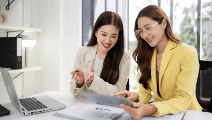 Two HR professionals in Indonesia reviewing hiring metrics on a tablet—Indonesia labour market 2025 planning for 2026.